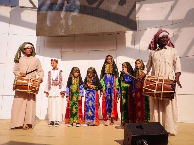 Nel Padiglione del Qatar, bambini festeggiano il Garangao, giorno in cui vanno di casa in casa a raccogliere dolcetti e frutta secca durante il Ramadan. A Expo hanno visitato i vicini padiglioni dei Paesi arabi, cantando una tradizionale canzone popolare (Ansa)
